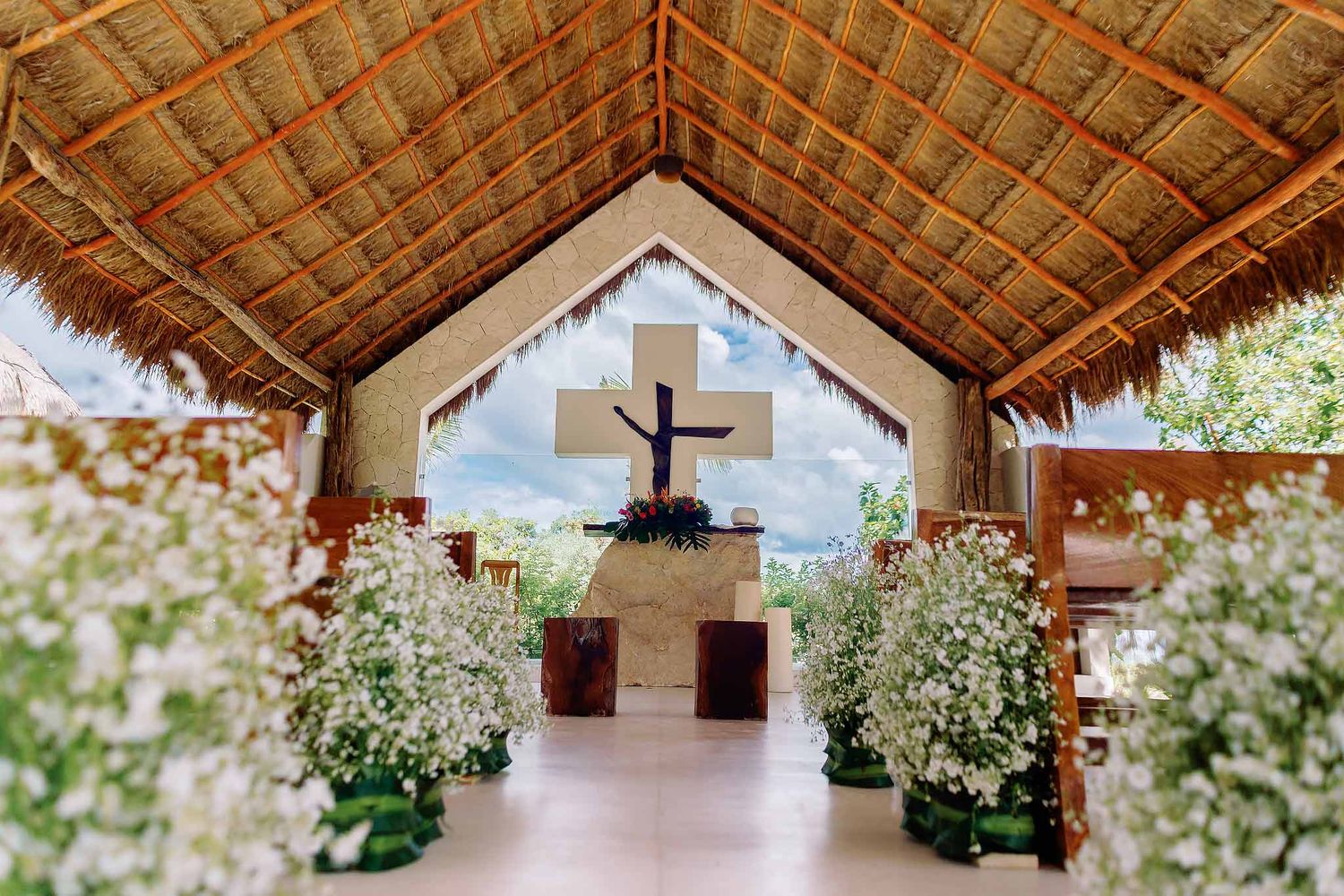 Catholic beach wedding chapel altar with floral aisle decor at Jardín del Mar Cancun