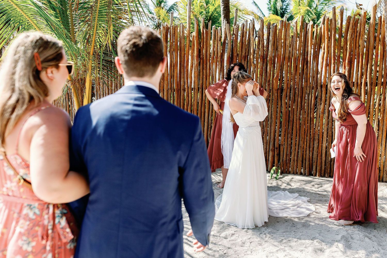 Nicole covers her eyes as Thomas approaches for their first touch before the intimate Blue Venado wedding ceremony in Playa del Carmen.