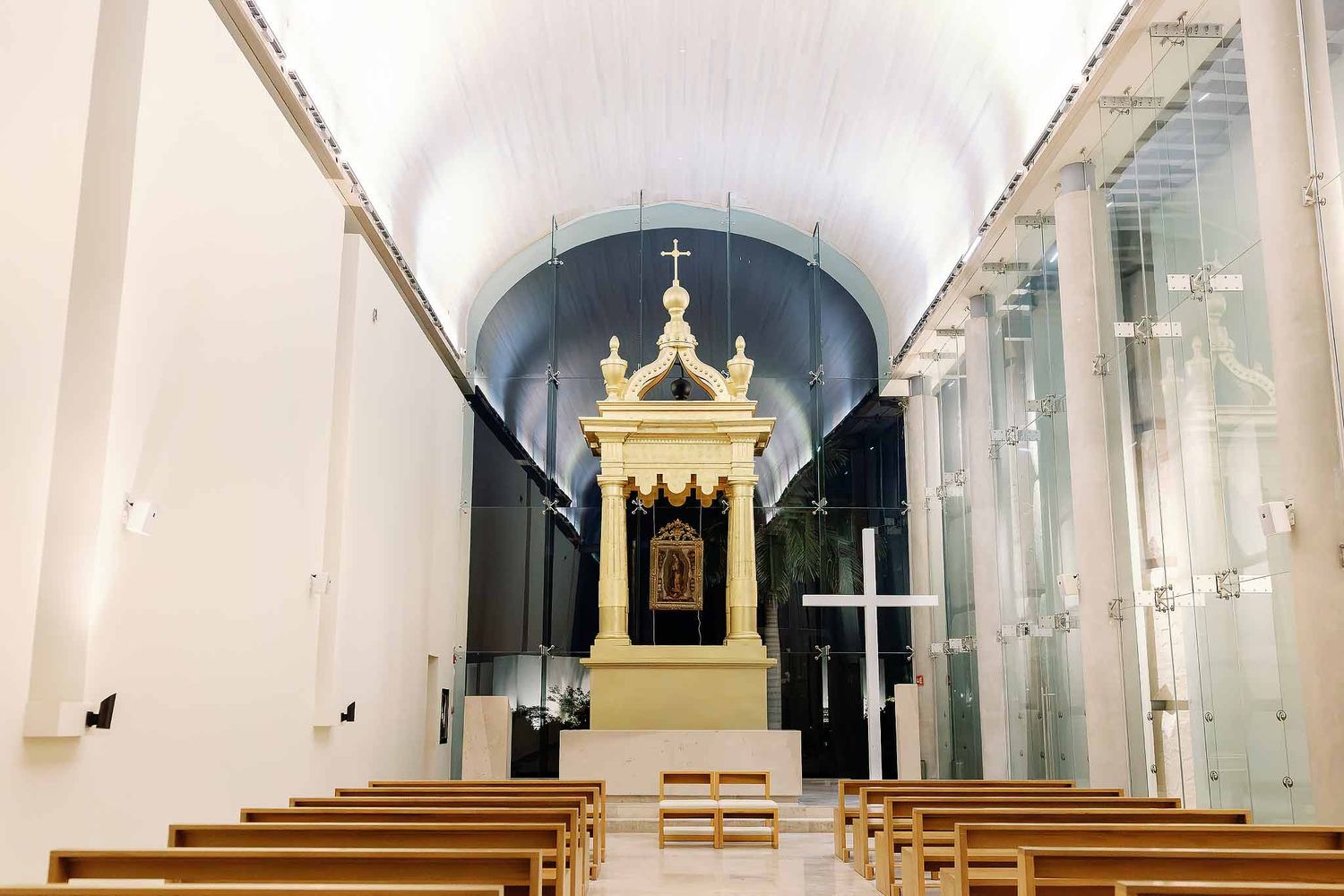 Interior of Our Lady of Rocío Catholic wedding chapel at Grand Palladium Costa Mujeres with altar and wooden pews