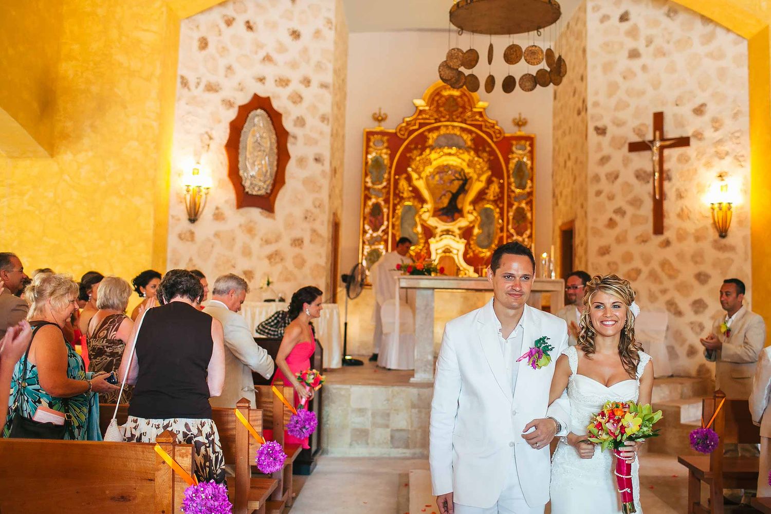 Bride and groom walking down aisle at Our Lady of Paradise Chapel Iberostar Riviera Maya after Catholic wedding ceremony