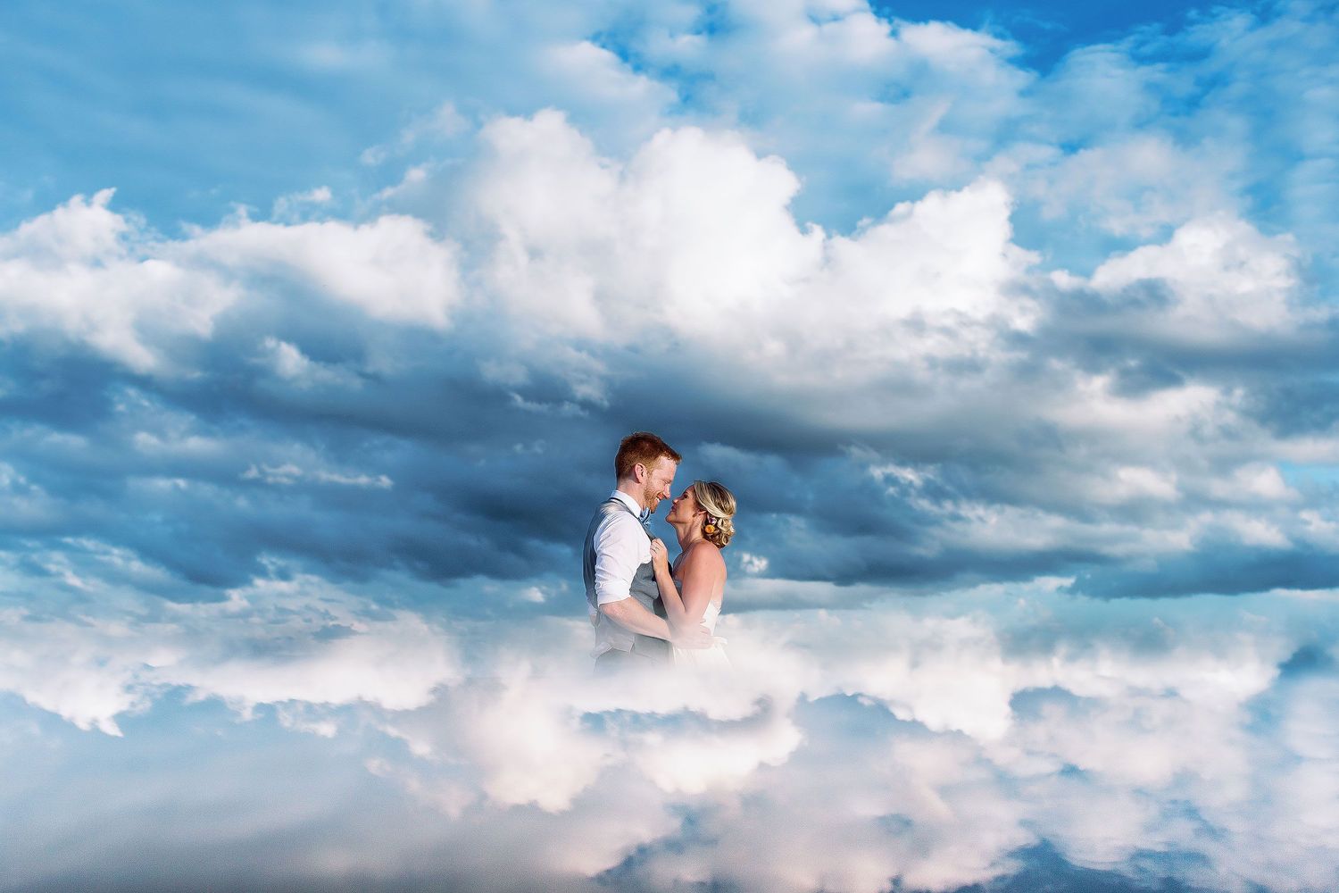 Cressida and Alan embracing in a creative cloud-inspired wedding portrait photographed at a private Riviera Maya beach.