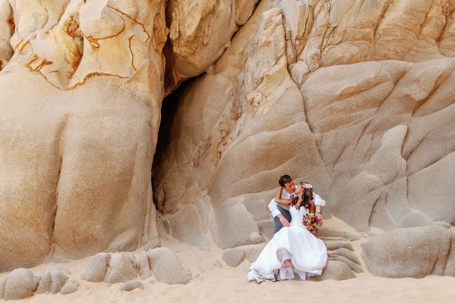 Romantic wedding portrait in Cabo San Lucas featuring dramatic desert rock formations and the natural beauty of Los Cabos.