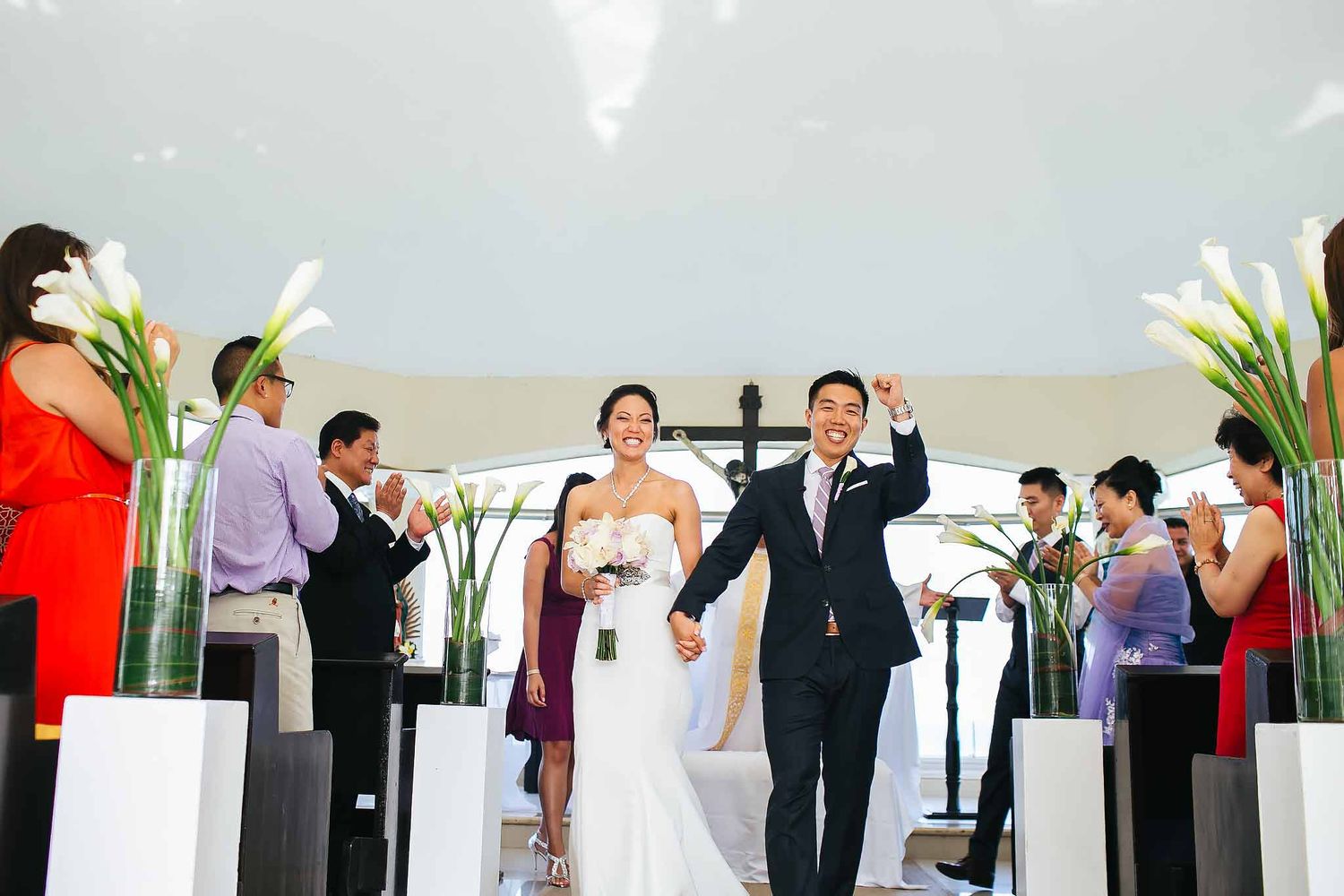 Bride and groom celebrating after Catholic wedding ceremony at Moon Palace Cancun Chapel of the Immaculate Conception