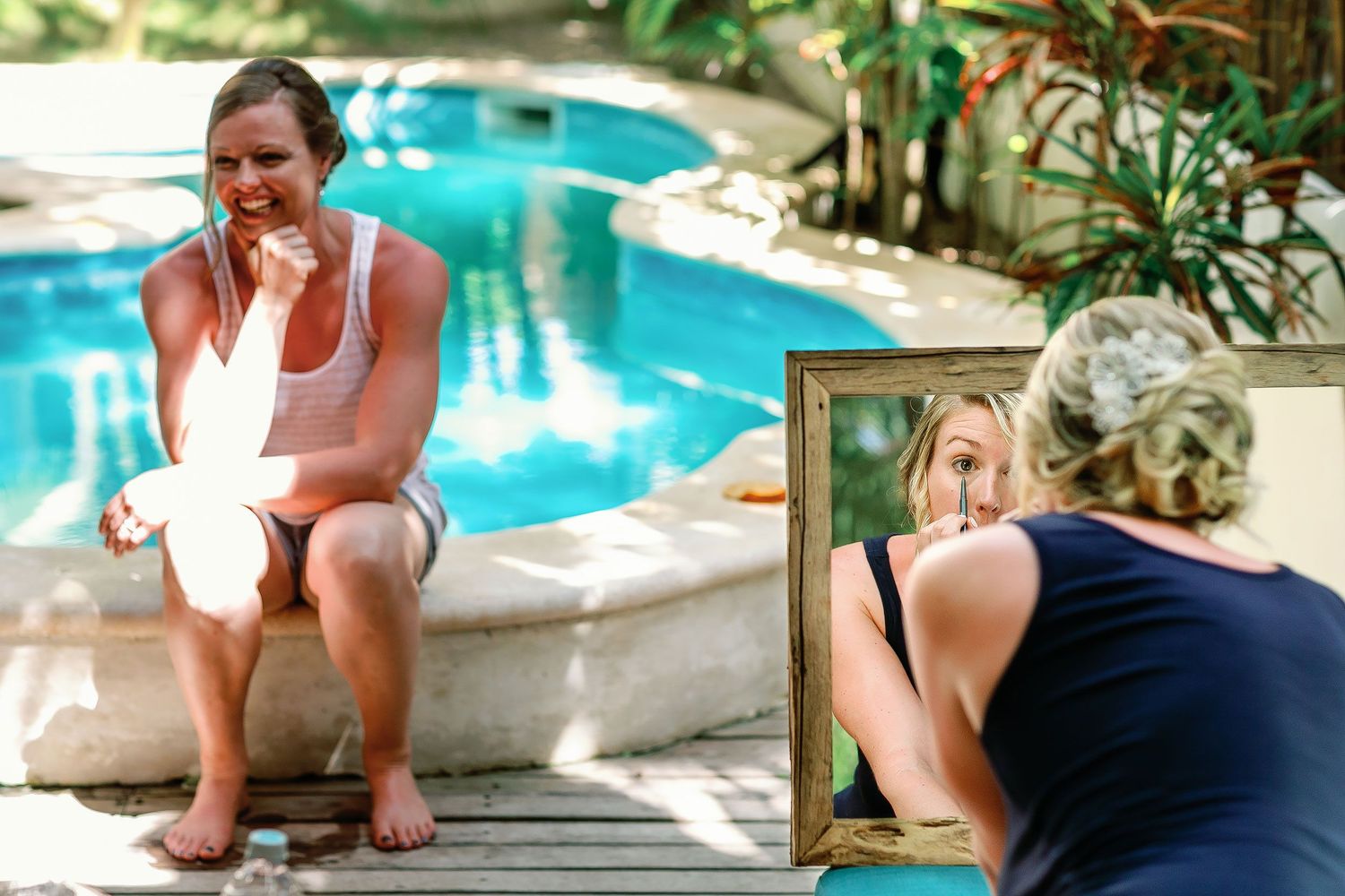Ashley applies her makeup beside the pool while getting ready at a private Tulum house.