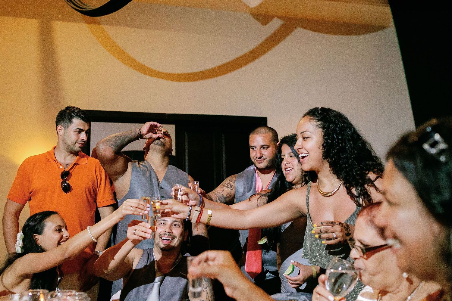 Wedding guests raise their glasses for a lively toast during the nightclub reception.