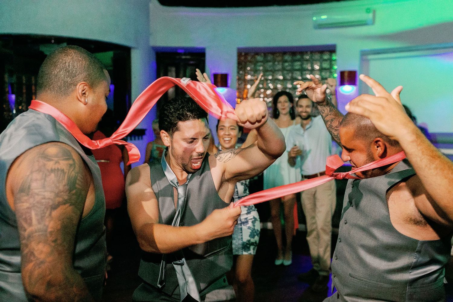 Keith dances energetically with his groomsmen and their coral ties.