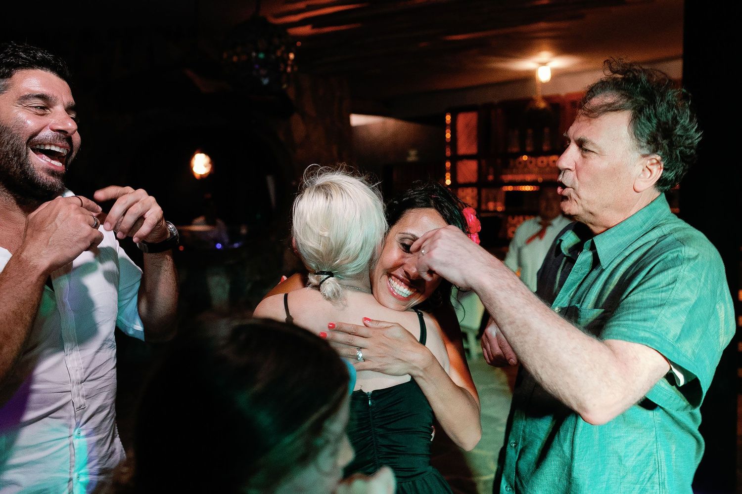 Wedding guests laugh and embrace on the dance floor at Fragata Beach Club.