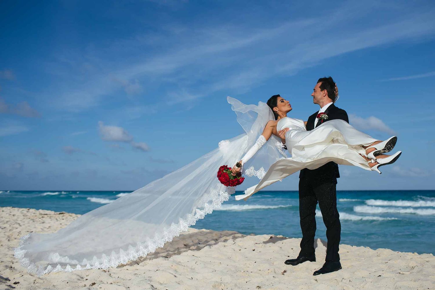Elegant bride and groom portrait on the beach at Sunscape Sabor Cozumel captured by a Cozumel wedding photographer with flowing veil.