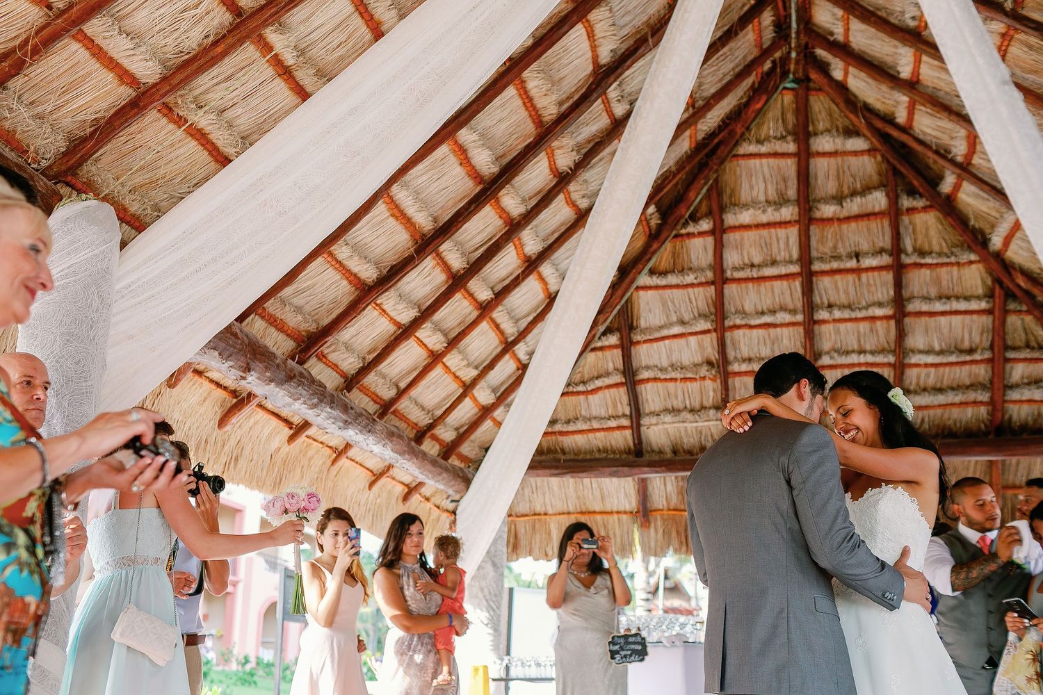 Felicitas and Keith share an affectionate embrace surrounded by their wedding guests.