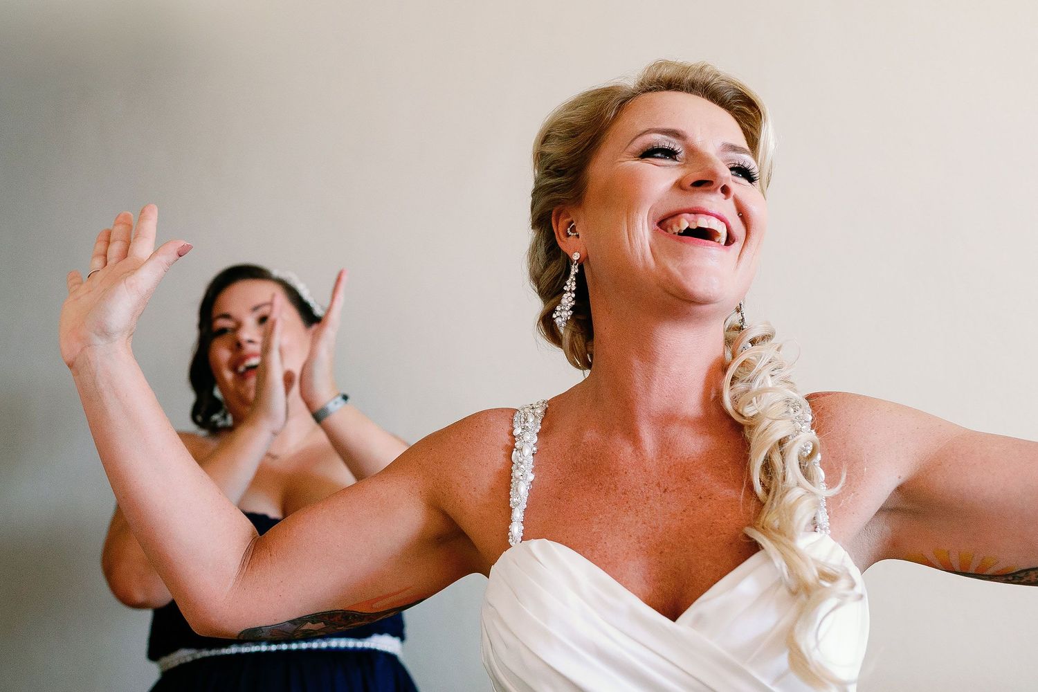 Carly laughing with a bridesmaid while getting ready for her wedding