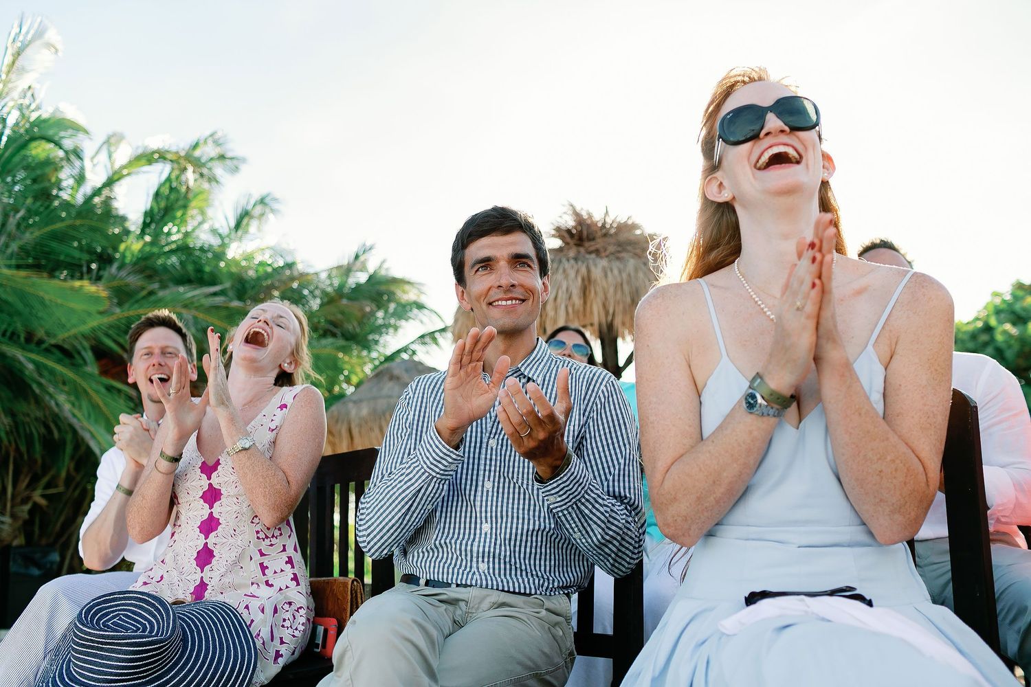 Wedding guests laughing and applauding during Cressida and Alan’s private beach ceremony in the Riviera Maya.