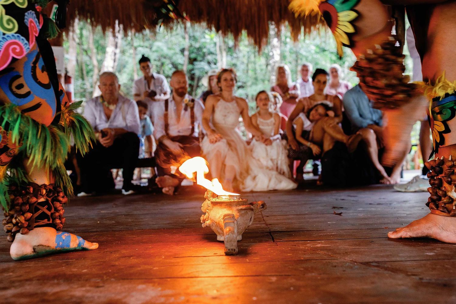 Jeff, Veronica, and their guests watching a fire performance beneath the palapa at Cenote Hats’uts near Playa del Carmen.