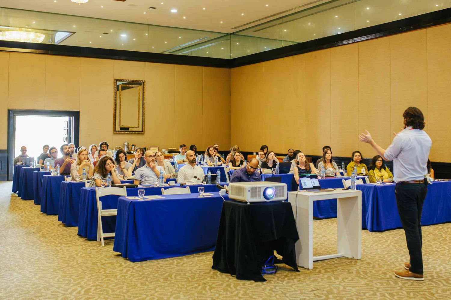 Business training workshop in Cancun with presenter speaking to audience during corporate conference session