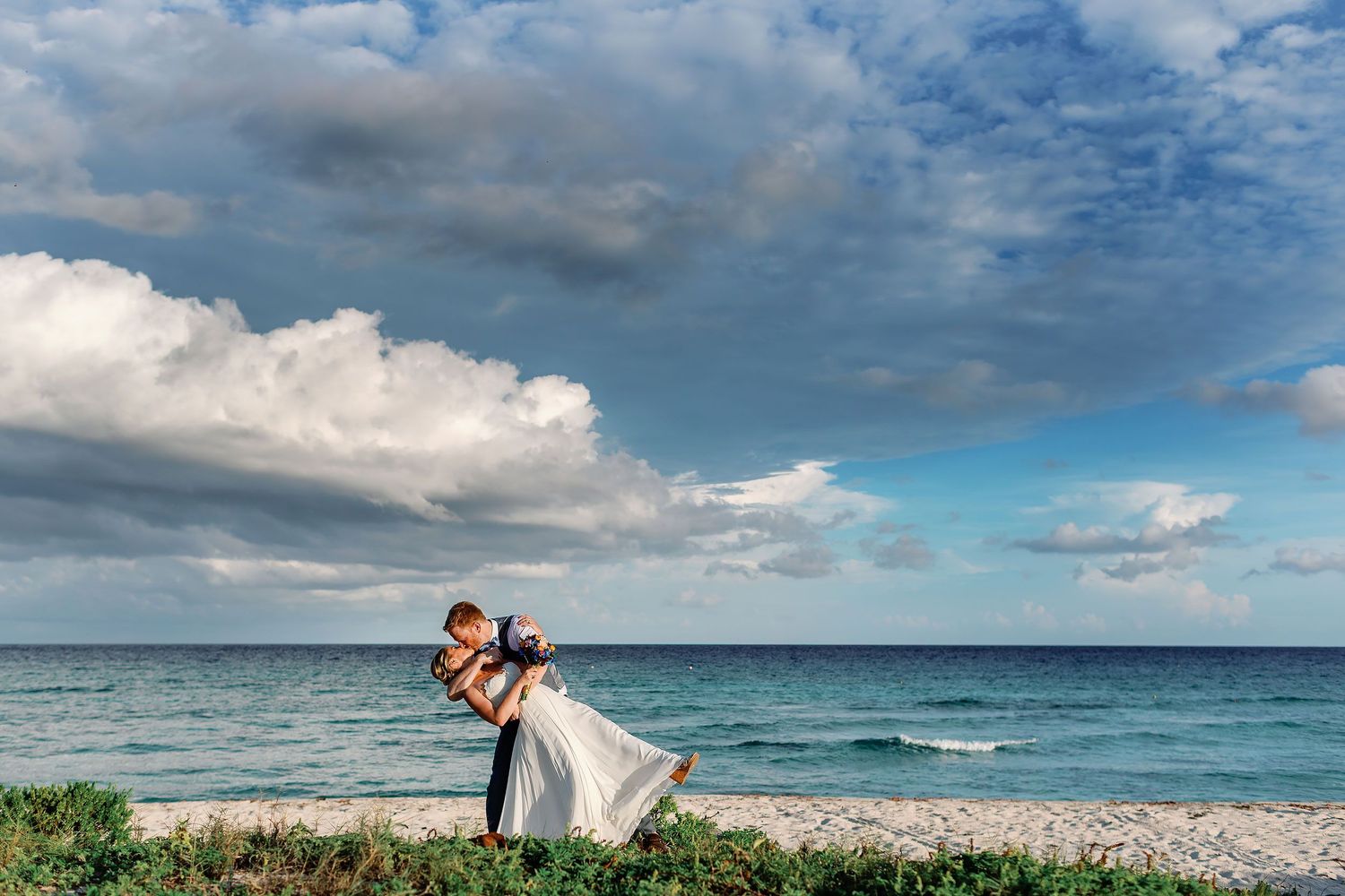 Alan dips Cressida for a romantic kiss during their wedding portrait session on a private beach in the Riviera Maya.