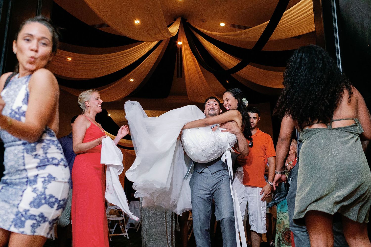 Keith carries a laughing Felicitas through the crowd during their wedding celebration.