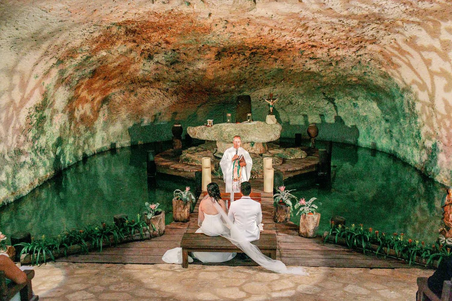 Catholic wedding ceremony inside Guadalupe Chapel cenote at Xcaret Park, unique Riviera Maya church wedding venue in Mexico