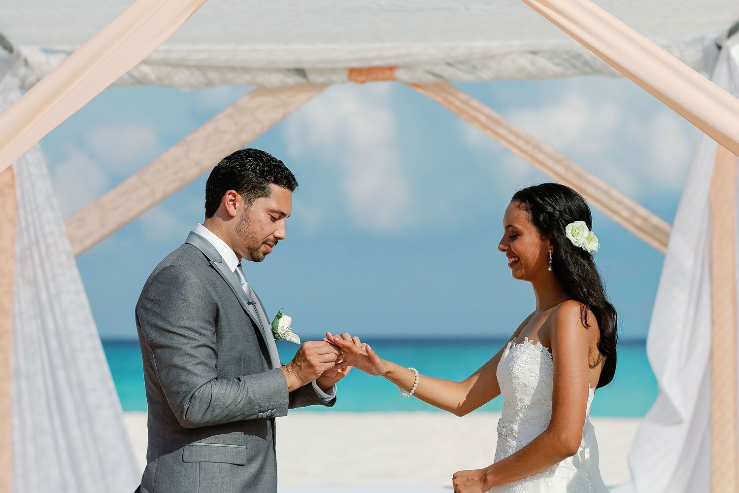Keith places a wedding ring on Felicitas’s finger during their seaside ceremony.