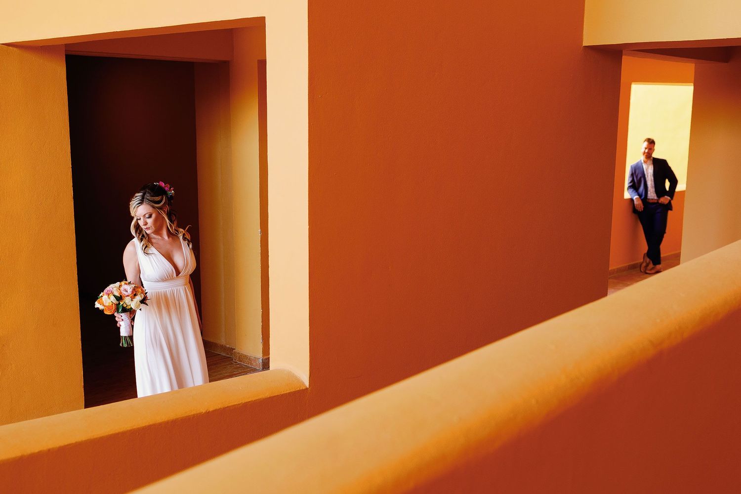 Bride and groom framed in separate archways during a creative wedding portrait at The Royal Haciendas in Playa del Carmen.