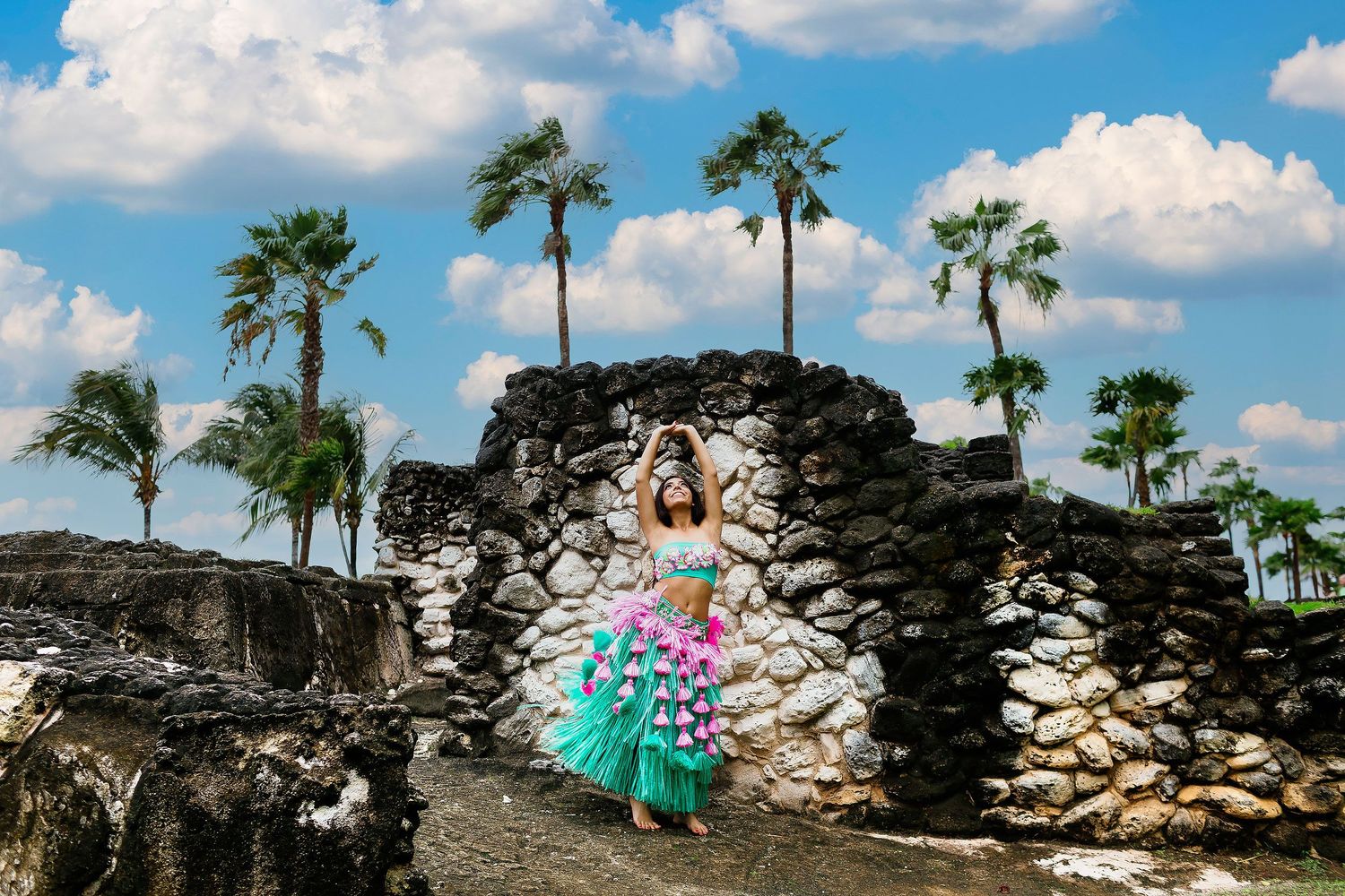 Sweet 15 portrait session in Cancun featuring cultural styling, stone architecture, palm trees, and Caribbean scenery.
