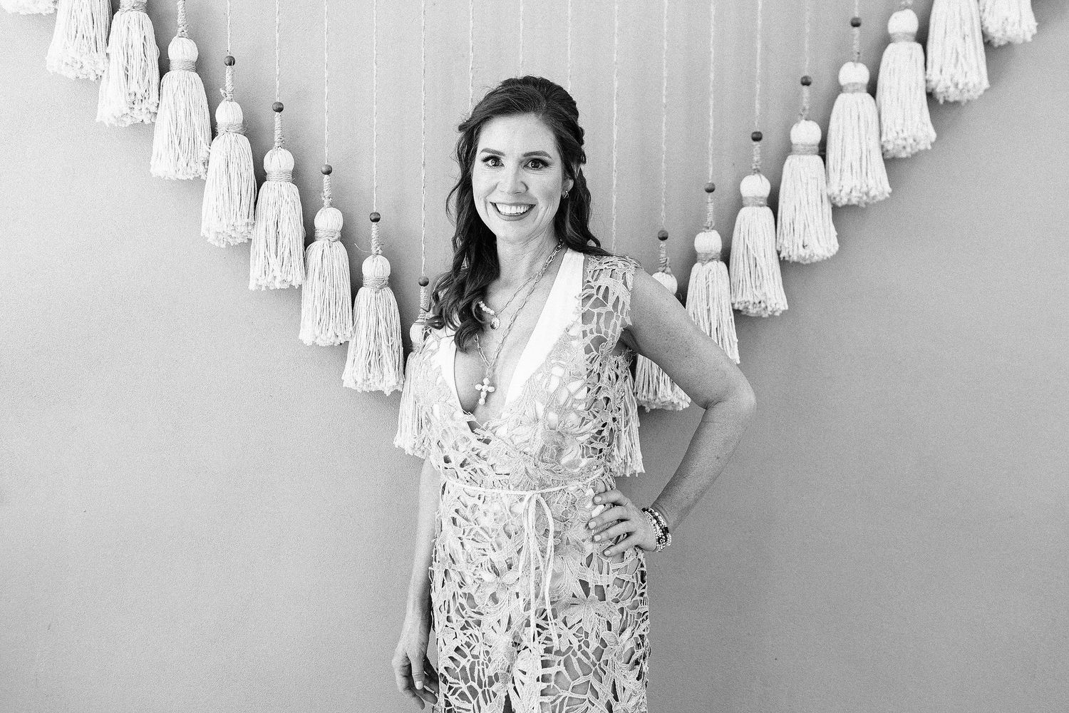 Black-and-white bridal portrait of Sarah smiling in her silver openwork dress.