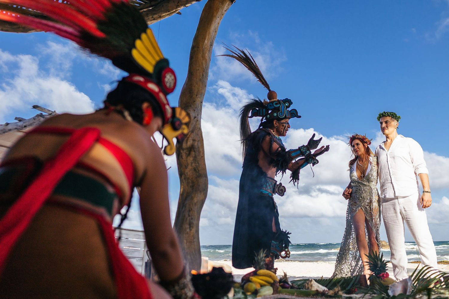 Sarah and Evish listen together during their intimate Tulum beach ceremony.