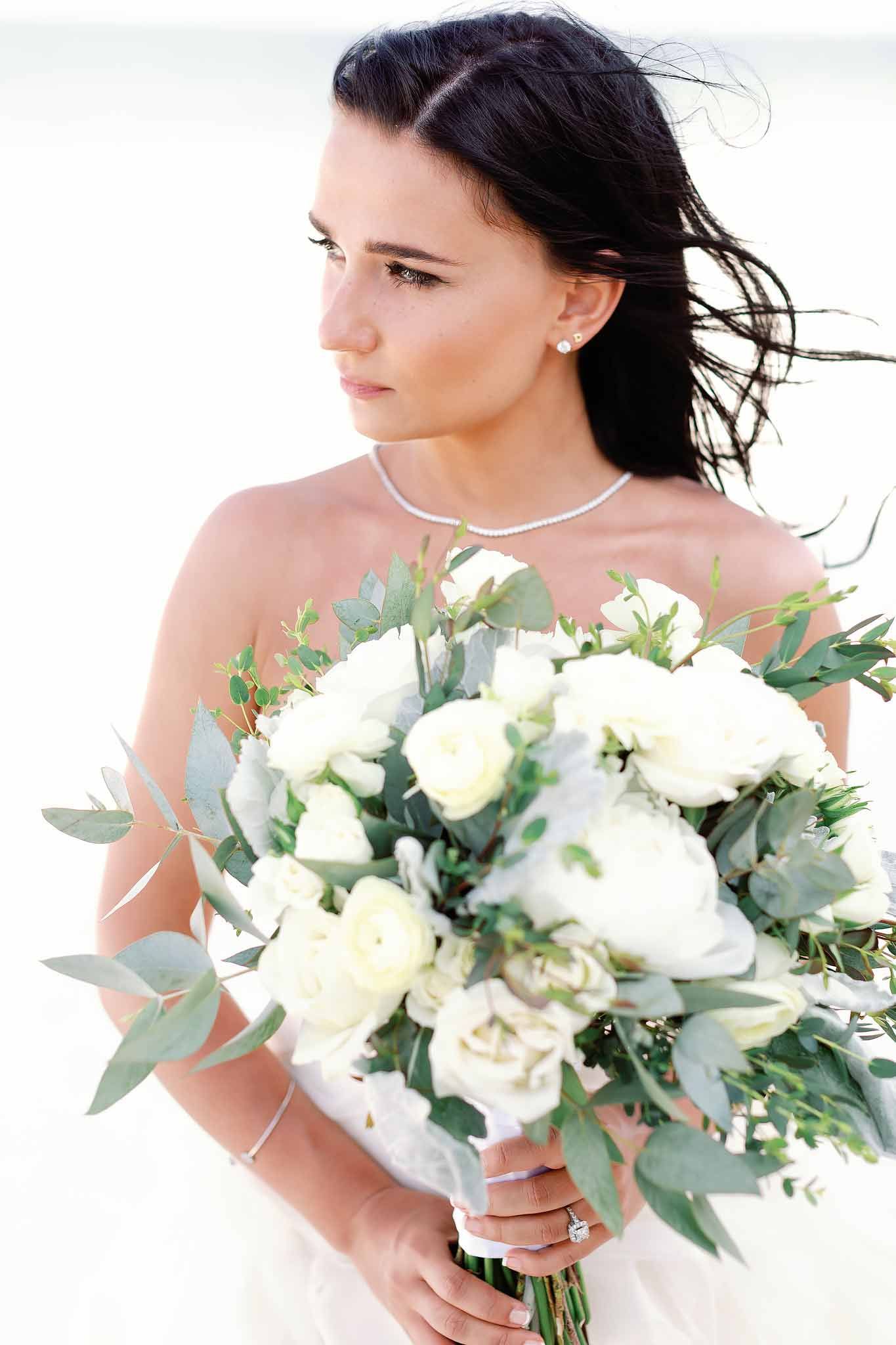 Bride portrait in Tulum holding white bouquet with soft natural light and beach setting in Riviera Maya