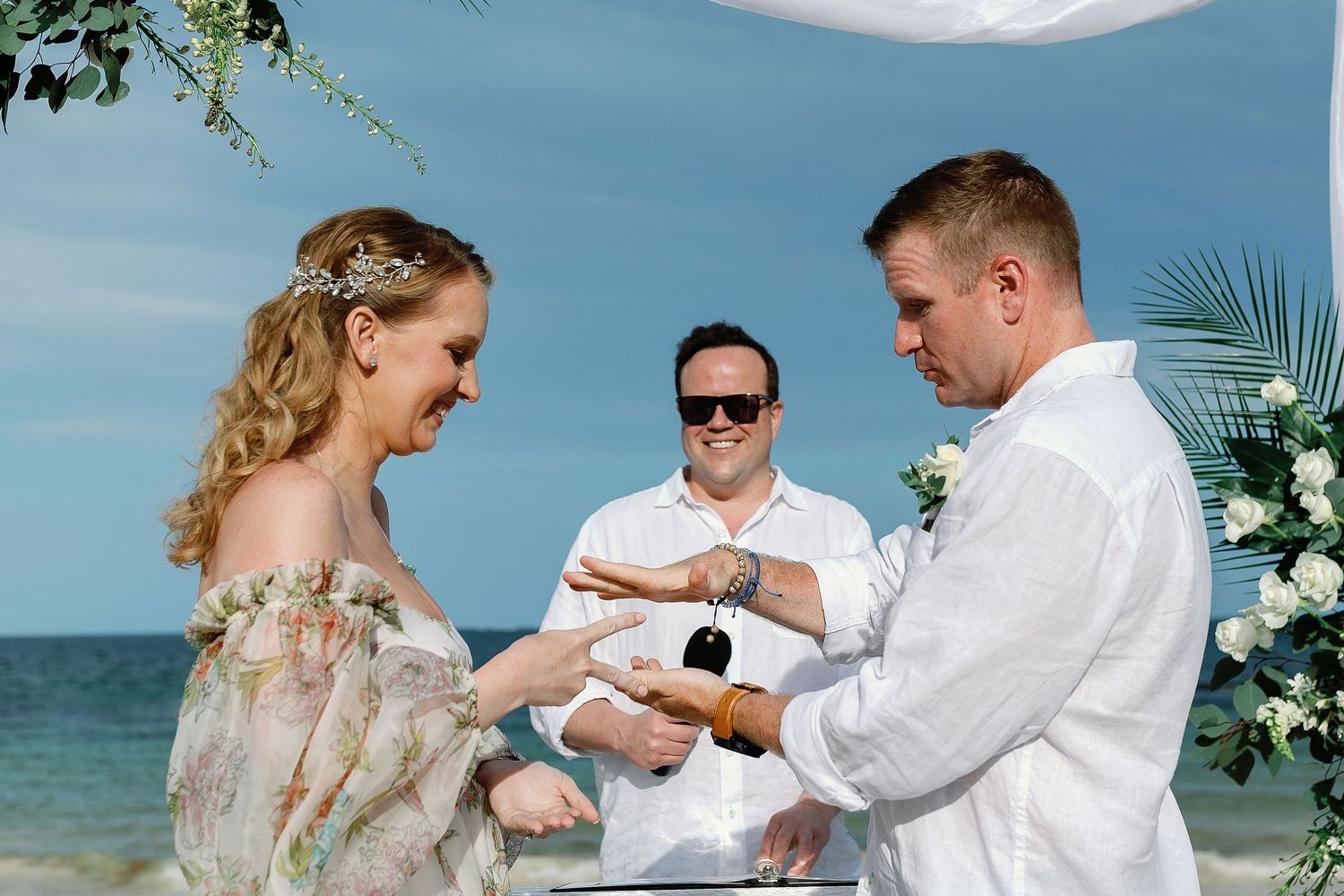 Autumn and Brian playing rock, paper, scissors during their relaxed beach reception at Dreams Sapphire in Puerto Morelos.
