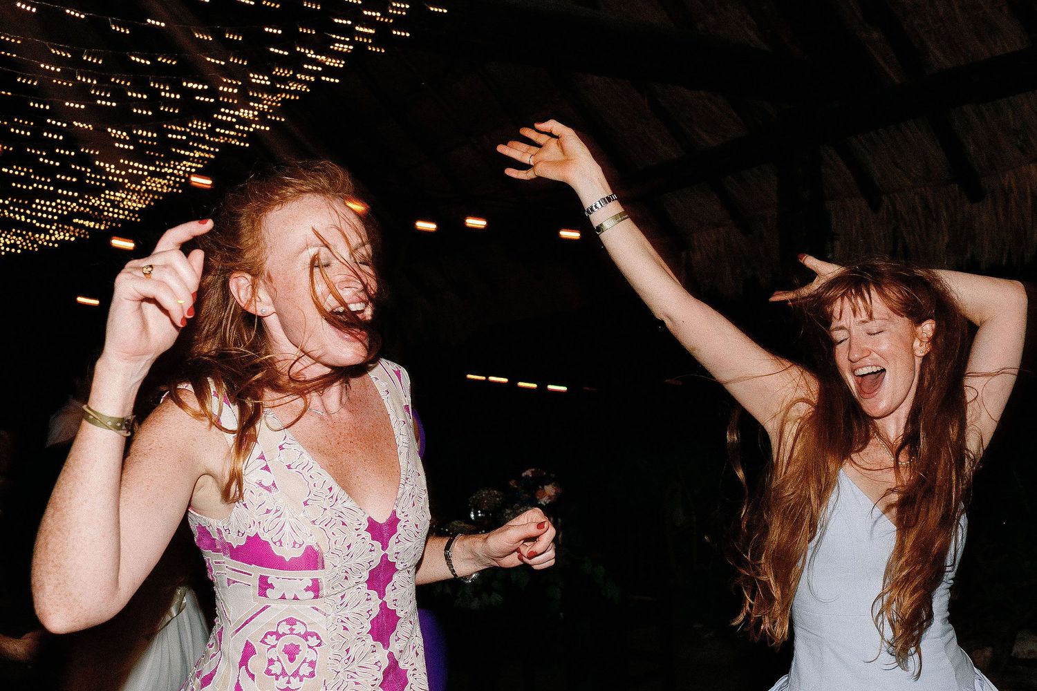 Wedding guests dancing beneath string lights during Cressida and Alan’s private Riviera Maya reception.