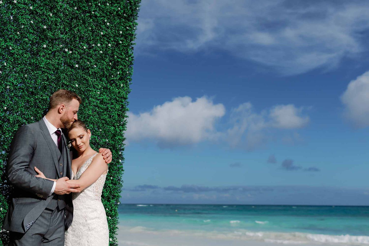 Romantic wedding couple portrait by the ocean in Playa del Carmen with turquoise Caribbean water and tropical backdrop
