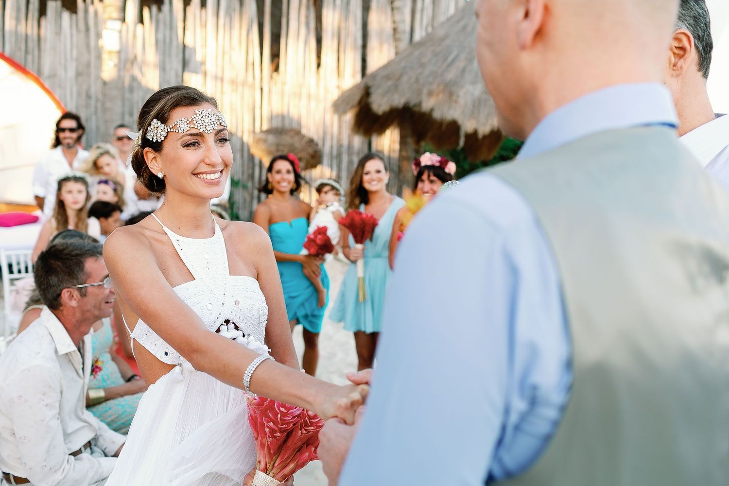 Juliana smiles at Tom while holding hands during their Playa del Carmen beach ceremony.