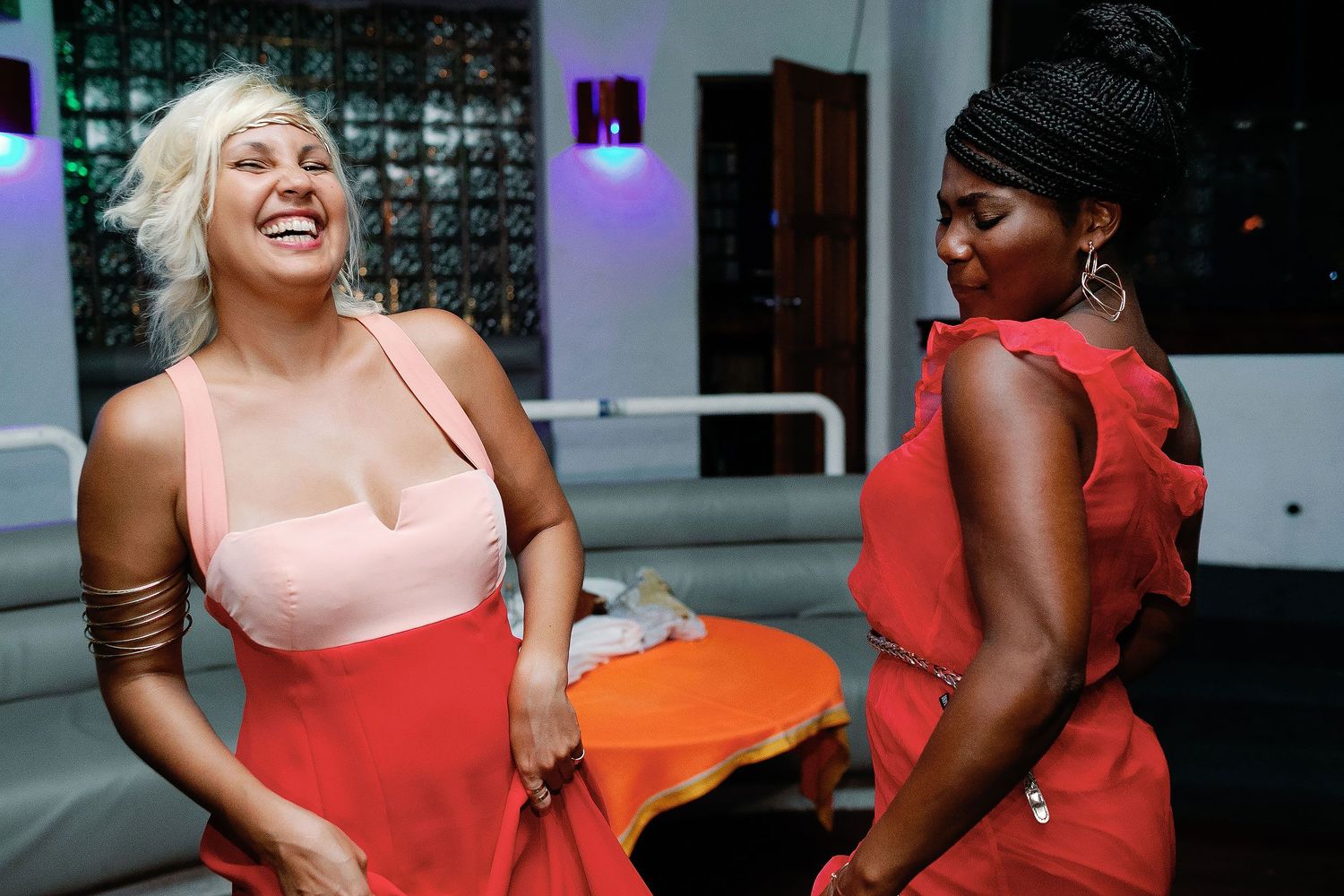 Two wedding guests laugh and dance together inside the Sandos Playacar nightclub.