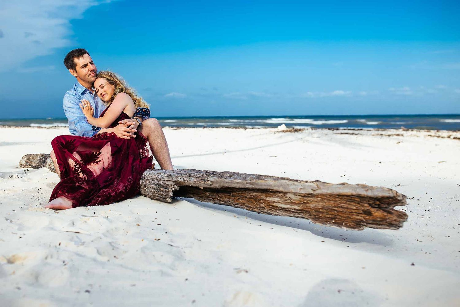 Romantic Riviera Maya engagement photography with couple embracing on a white sand beach in Cancun Mexico
