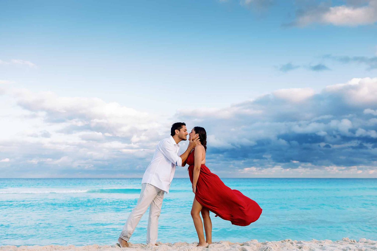 Romantic Cancun engagement photography with couple kissing on a turquoise Caribbean beach at sunset in Riviera Maya