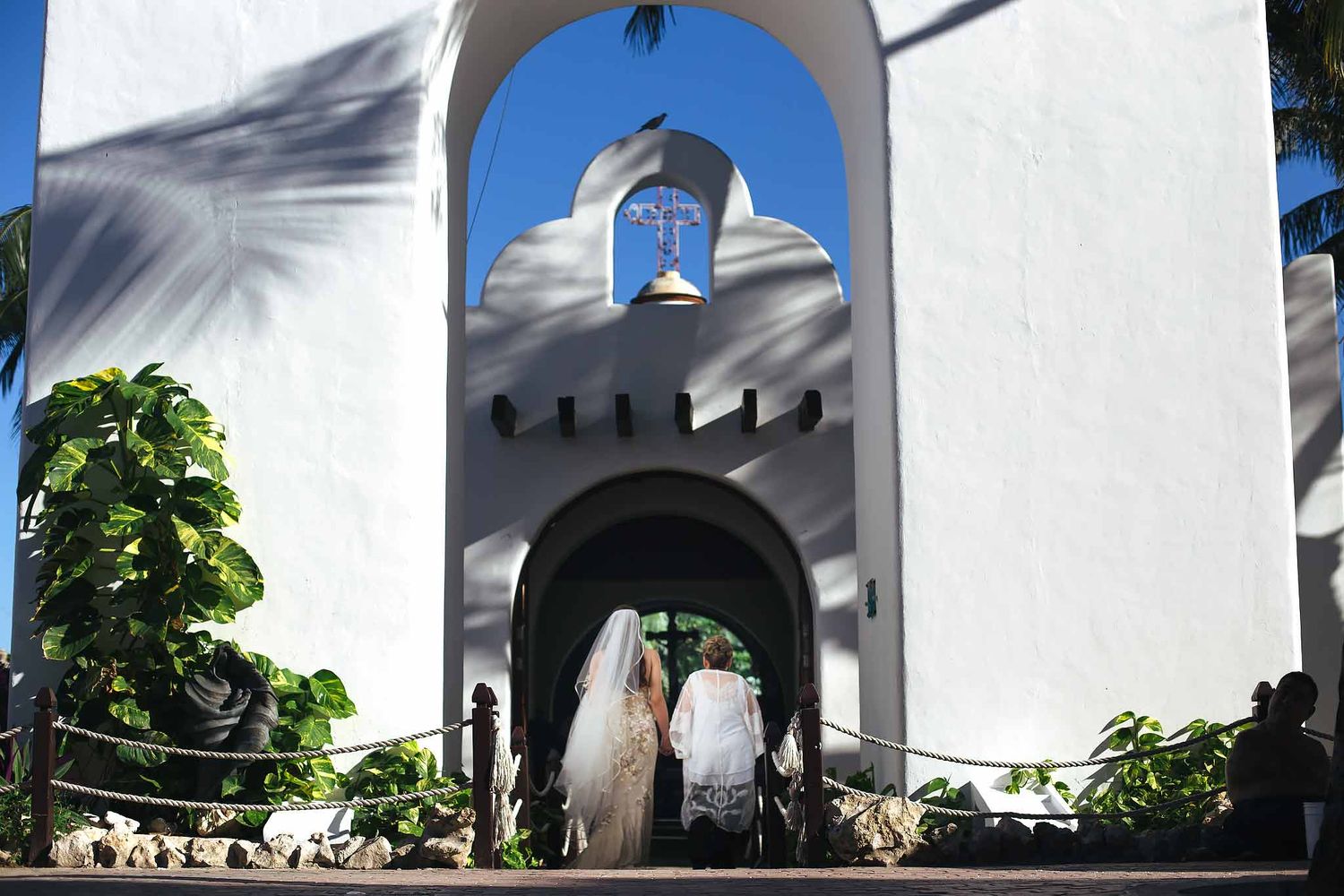 Bride walking into Our Lady of Carmen Catholic chapel on 5th Avenue Playa del Carmen for destination wedding ceremony