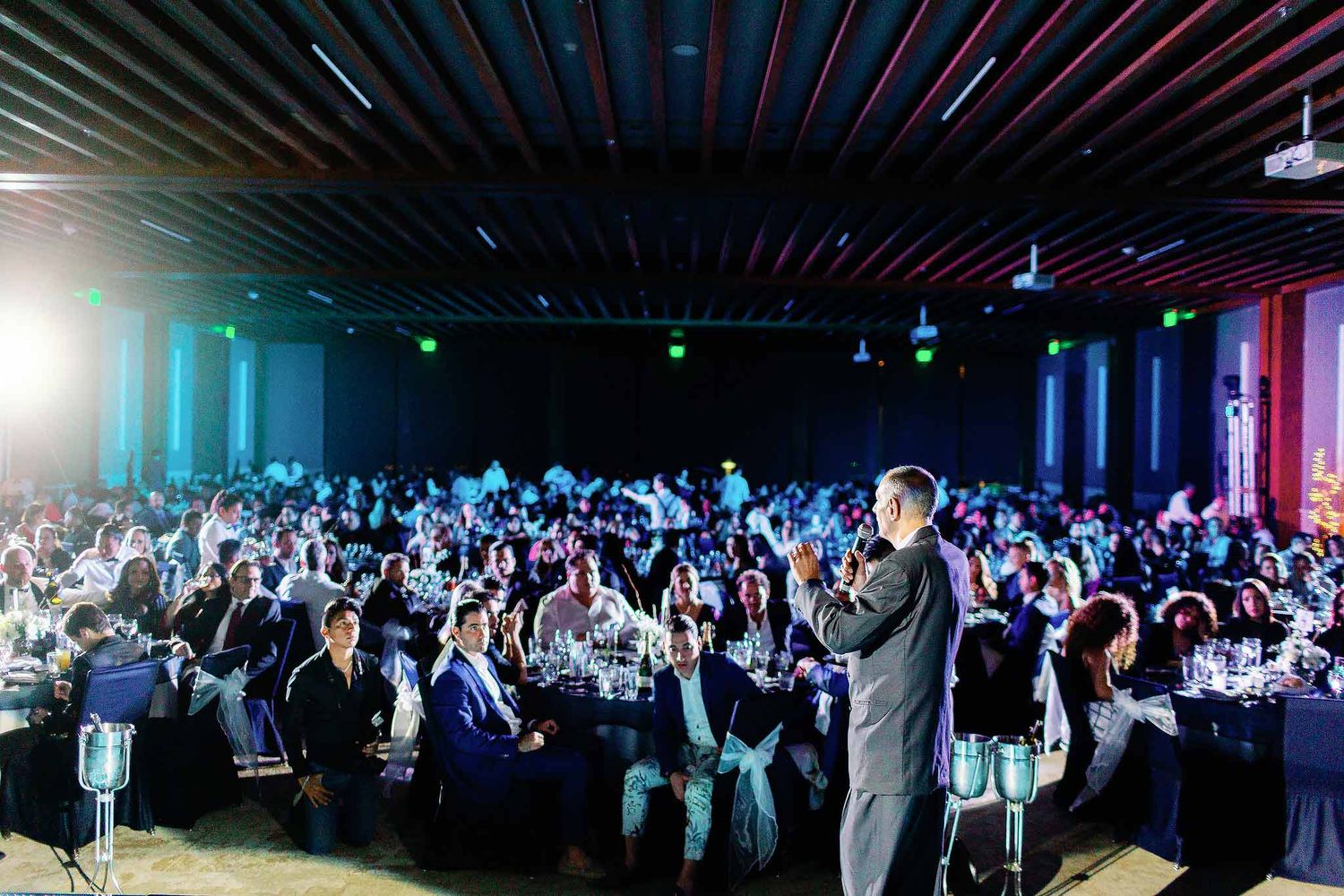Corporate event in Cancun with keynote speaker addressing a large audience during a conference gala dinner