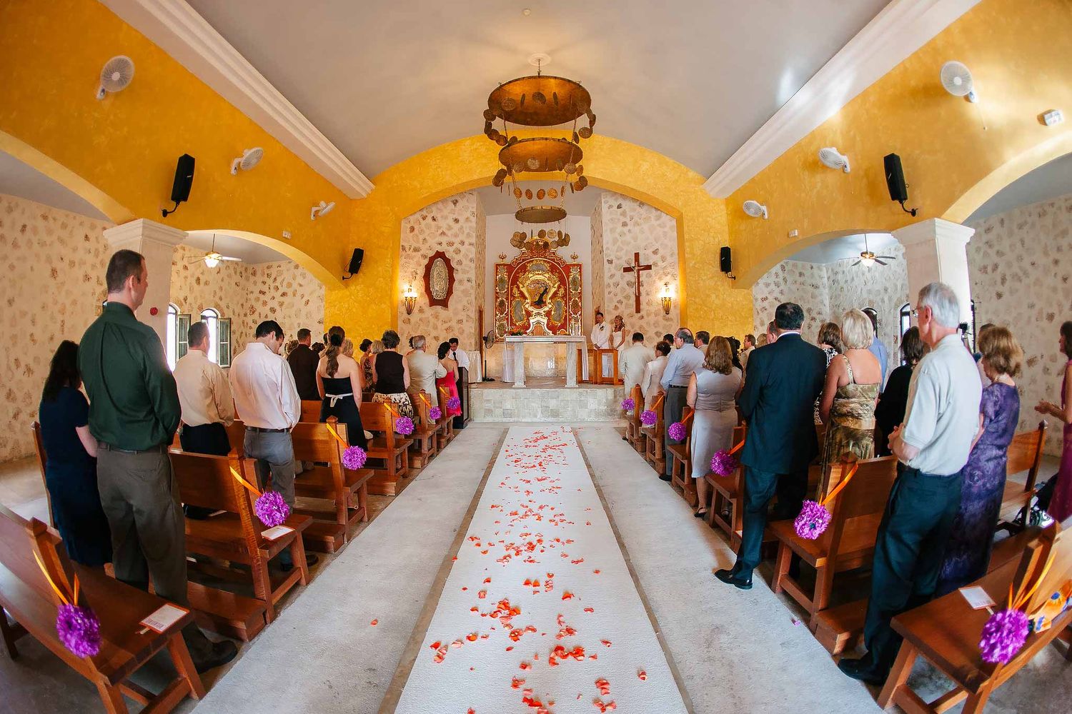Catholic wedding ceremony at Our Lady of Paradise Chapel Iberostar Riviera Maya with decorated aisle and guests inside church
