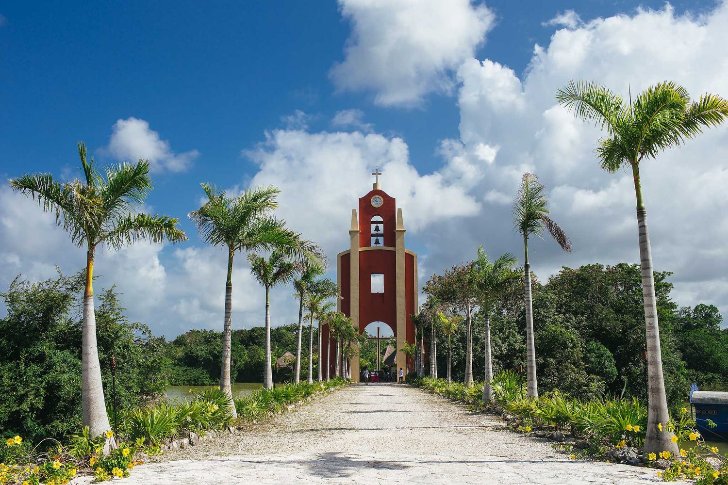 Floating Catholic wedding chapel at Xoximilco Riviera Maya Cancun, Capilla del Niño with palm-lined pathway and lagoon ceremony setting
