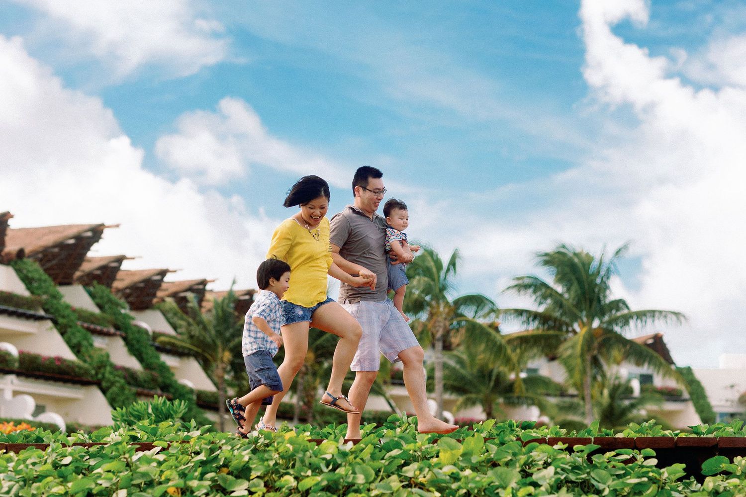 Family wearing casual tropical vacation outfits during a fun family photo session at Gran Velas Playa del Carmen, Riviera Maya.