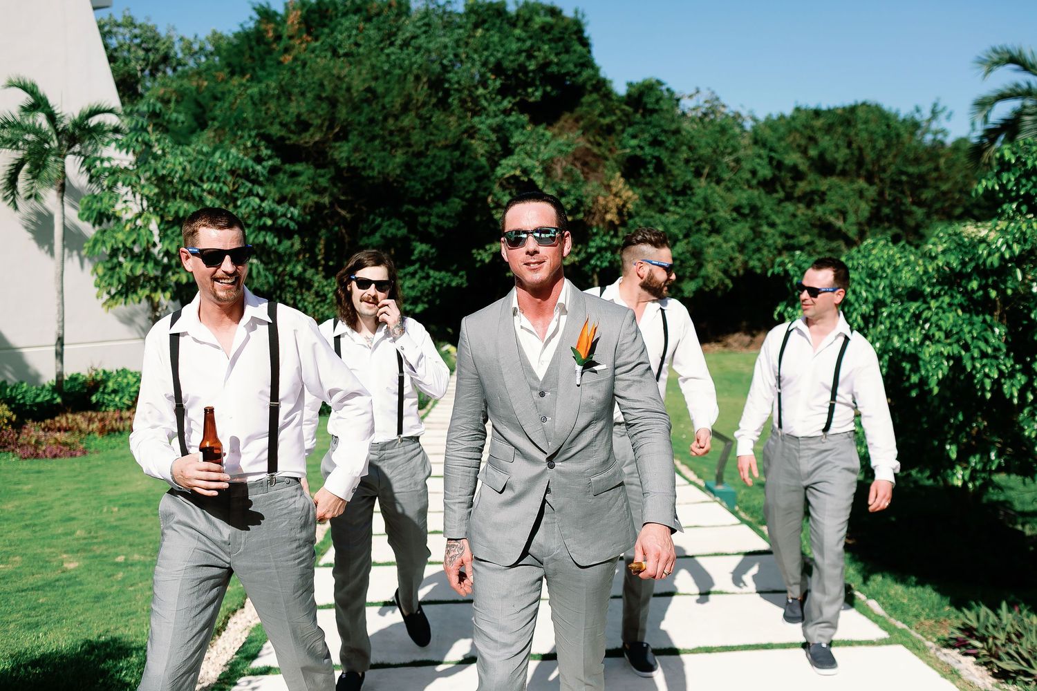 Scott walking with his groomsmen through the tropical resort gardens