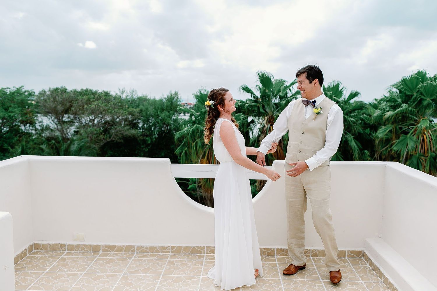 Li and Carlos laugh together during their rooftop first look at a private Isla Mujeres house.
