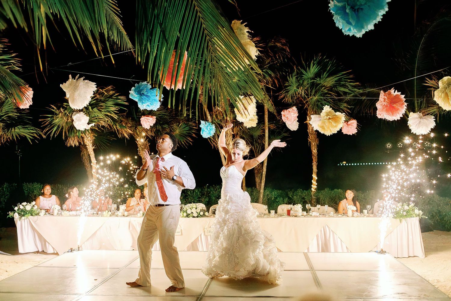 Bride and groom performing their first dance between sparkling fountains during their outdoor wedding reception at Barceló Maya Grand Resort