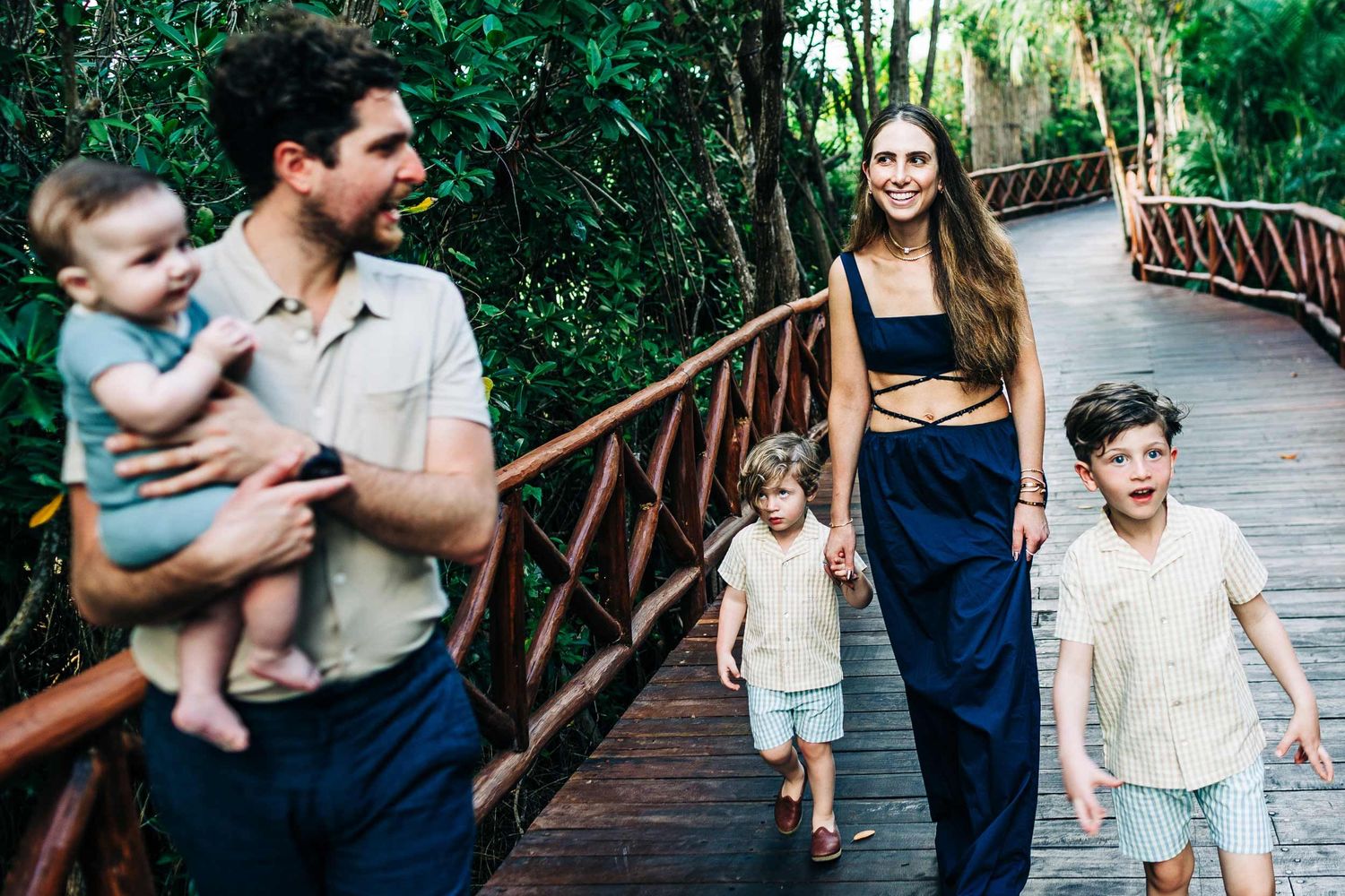 Family walking through tropical pathways at Fairmont Mayakoba during a candid Playa del Carmen family shoot.