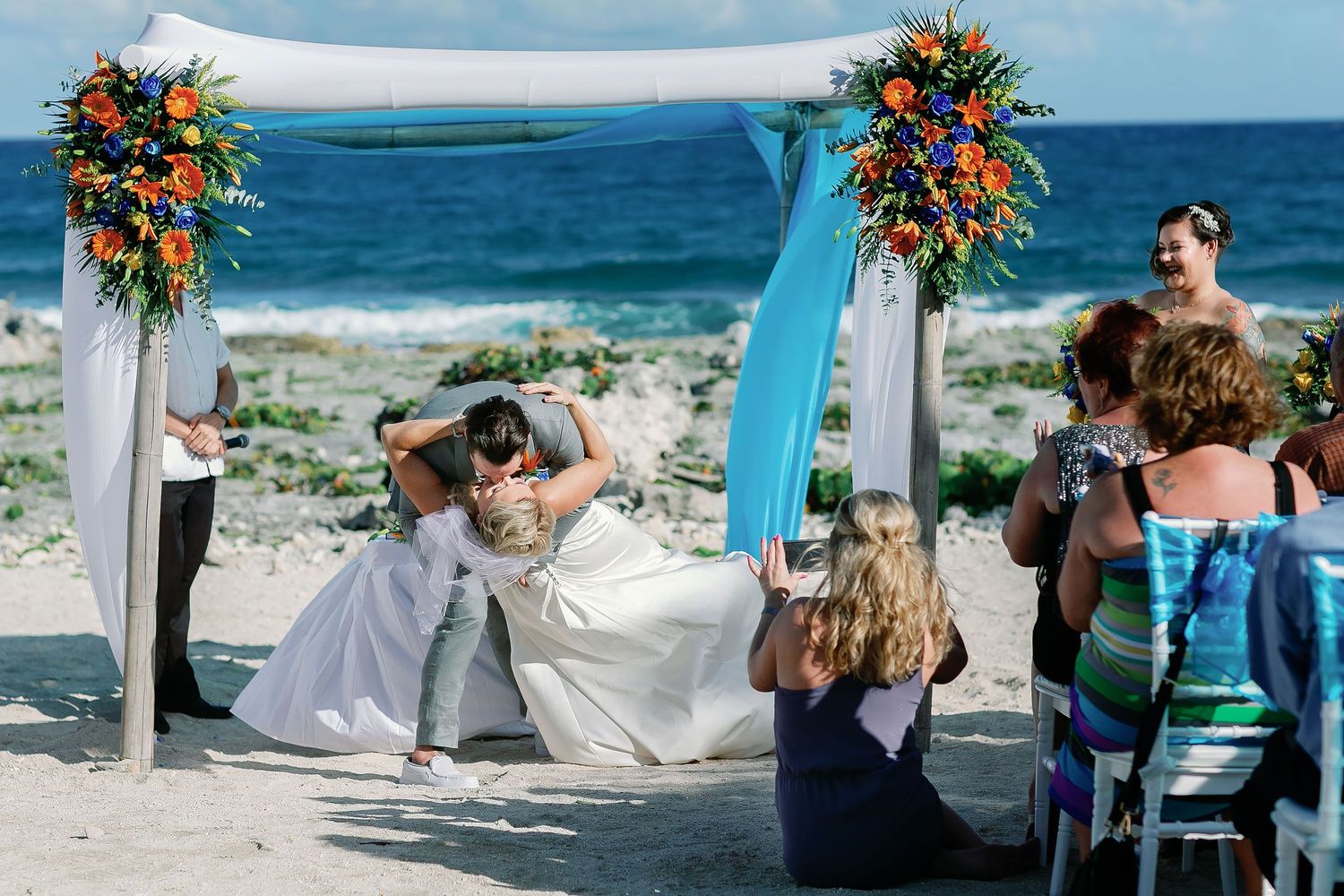 Scott dipping Carly for their first kiss at the beach wedding ceremony