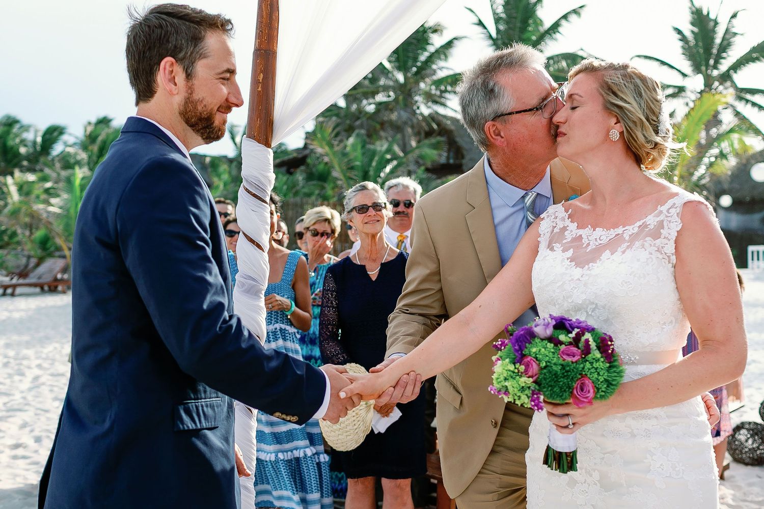 A loved one kisses Ashley before joining her hand with Matt’s at the Tulum beach ceremony