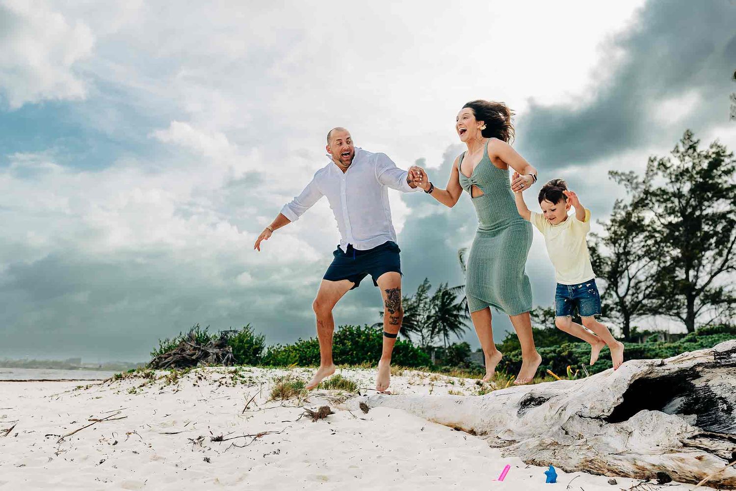Family running together during a candid beach photography session in Playa del Carmen