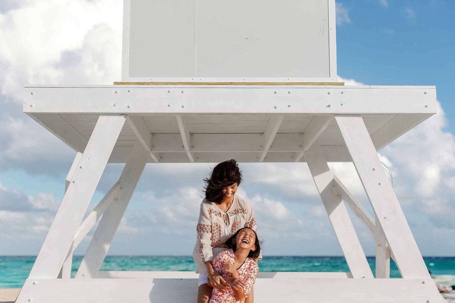 Family photographer in Cancun capturing candid moments between mother and child on a beach. Natural, timeless Riviera Maya photography