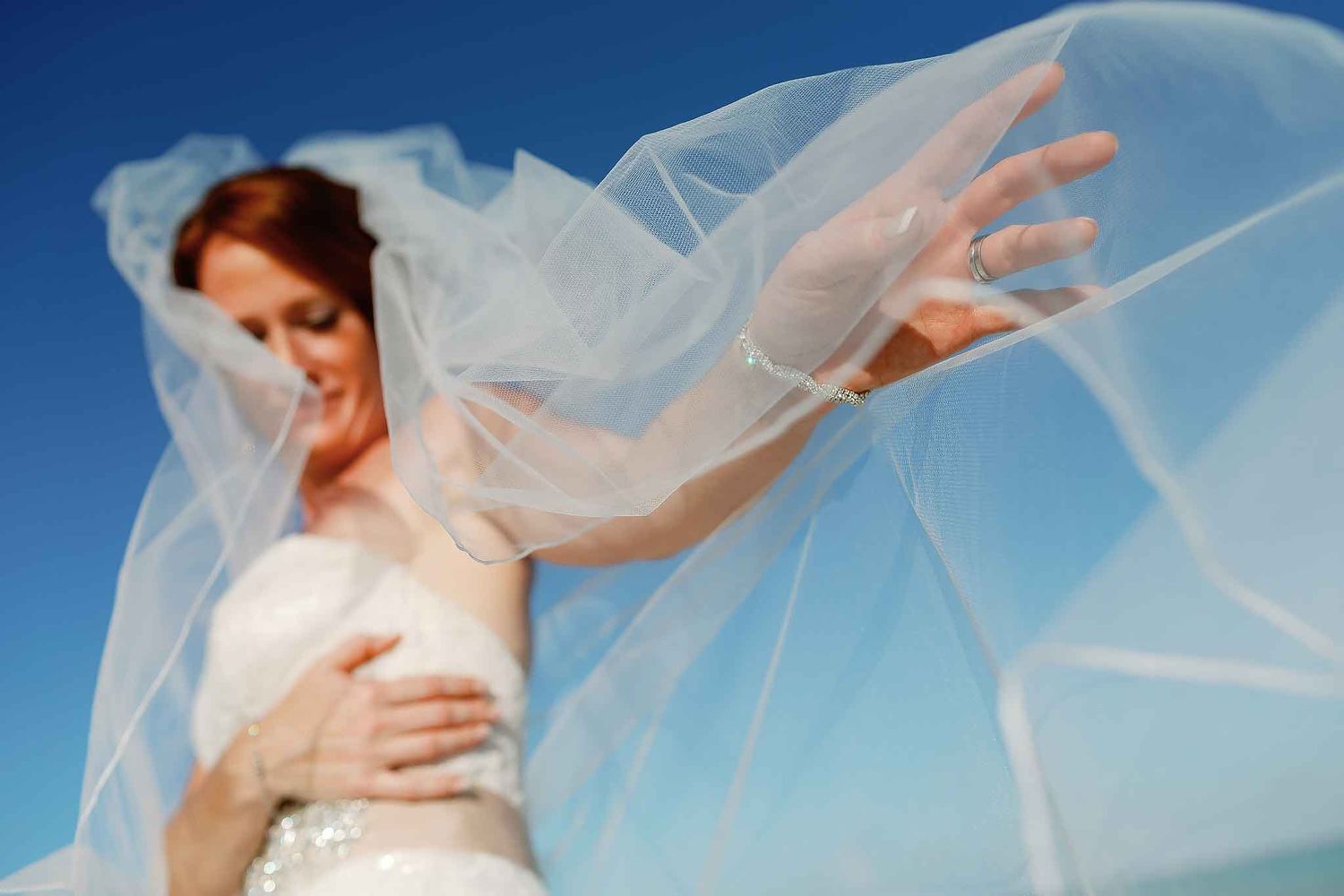 Isla Mujeres wedding photography of bride with flowing veil in soft Caribbean light and blue sky background
