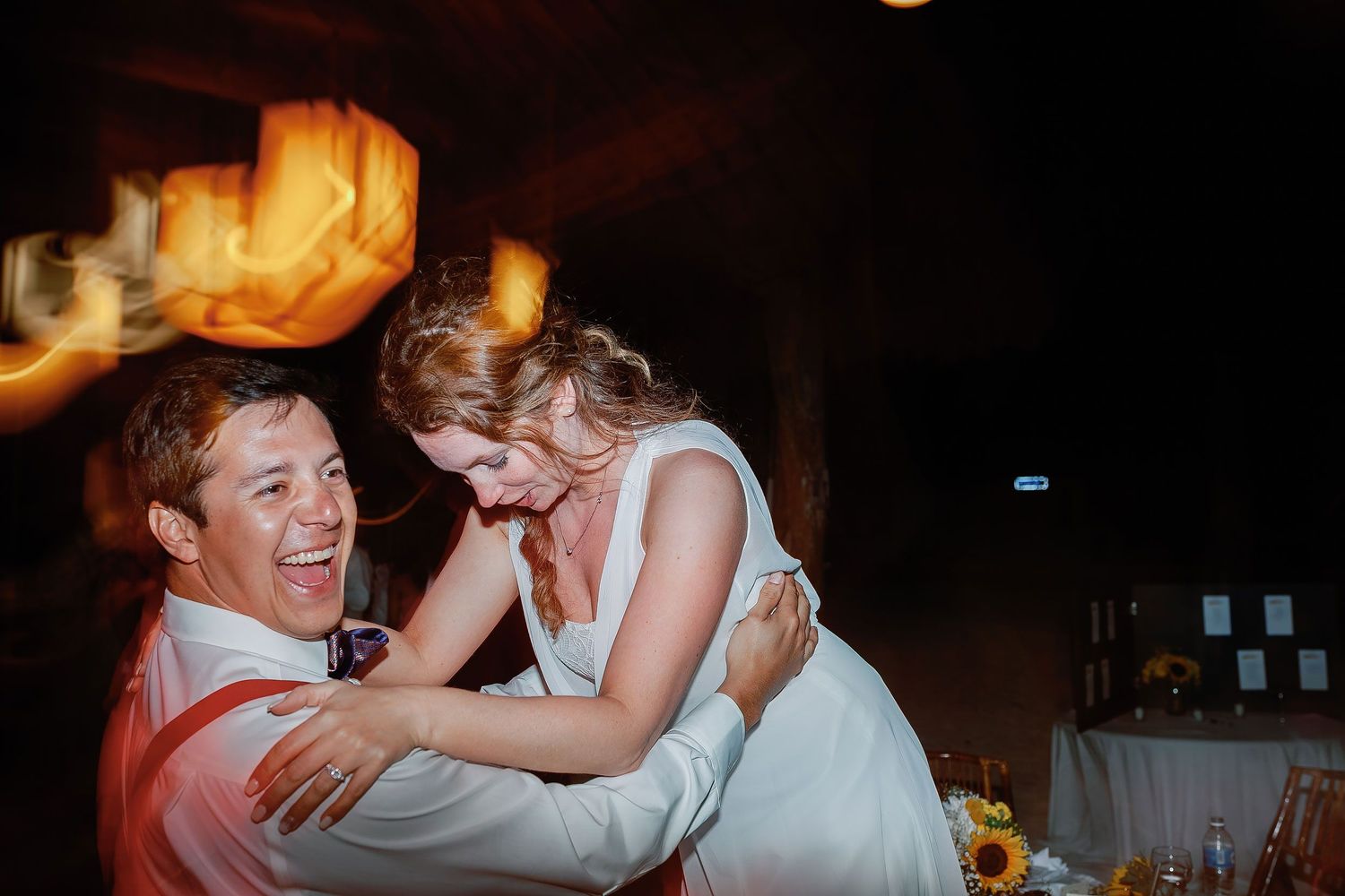 Carlos lifts Li as they laugh together on the reception dance floor in Isla Mujeres.