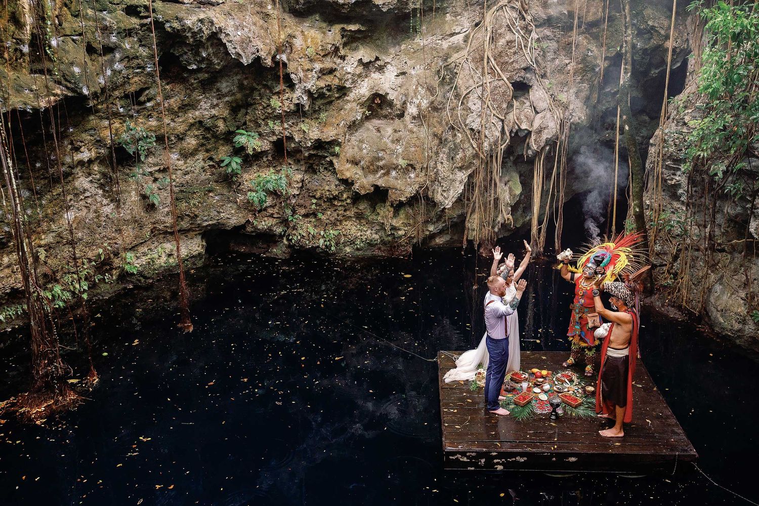 Wide view of Jeff and Veronica’s Maya wedding ceremony on a platform above the water at Cenote Hats’uts near Playa del Carmen.