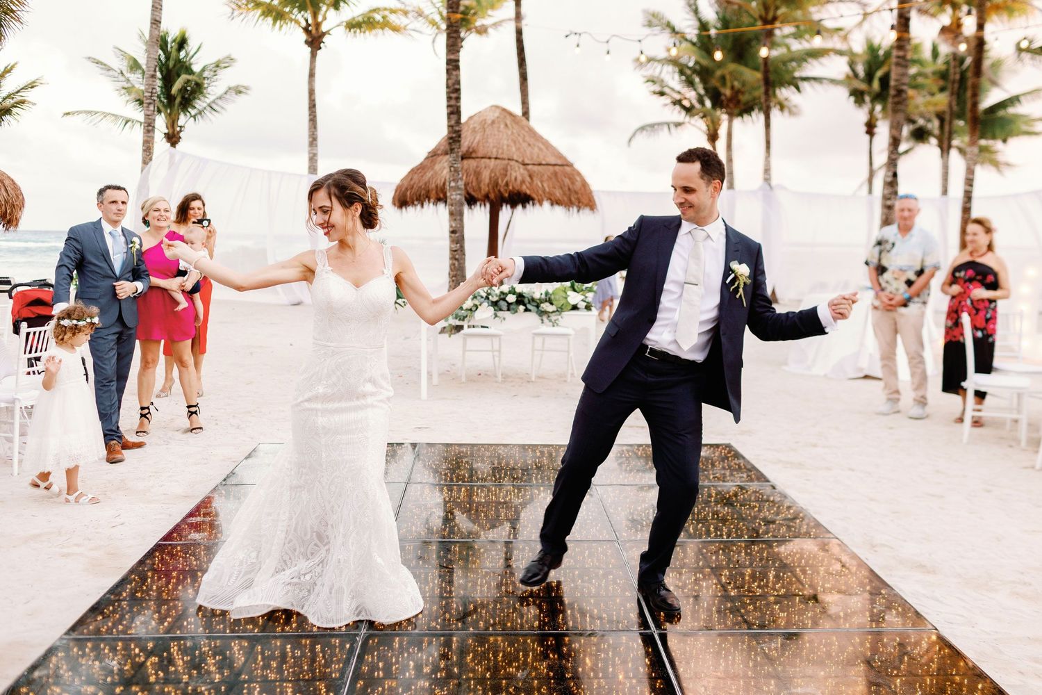 Newlyweds enjoying first dance on an illuminated floor during their beach reception at Grand Palladium White Sand Resort in the Riviera Maya